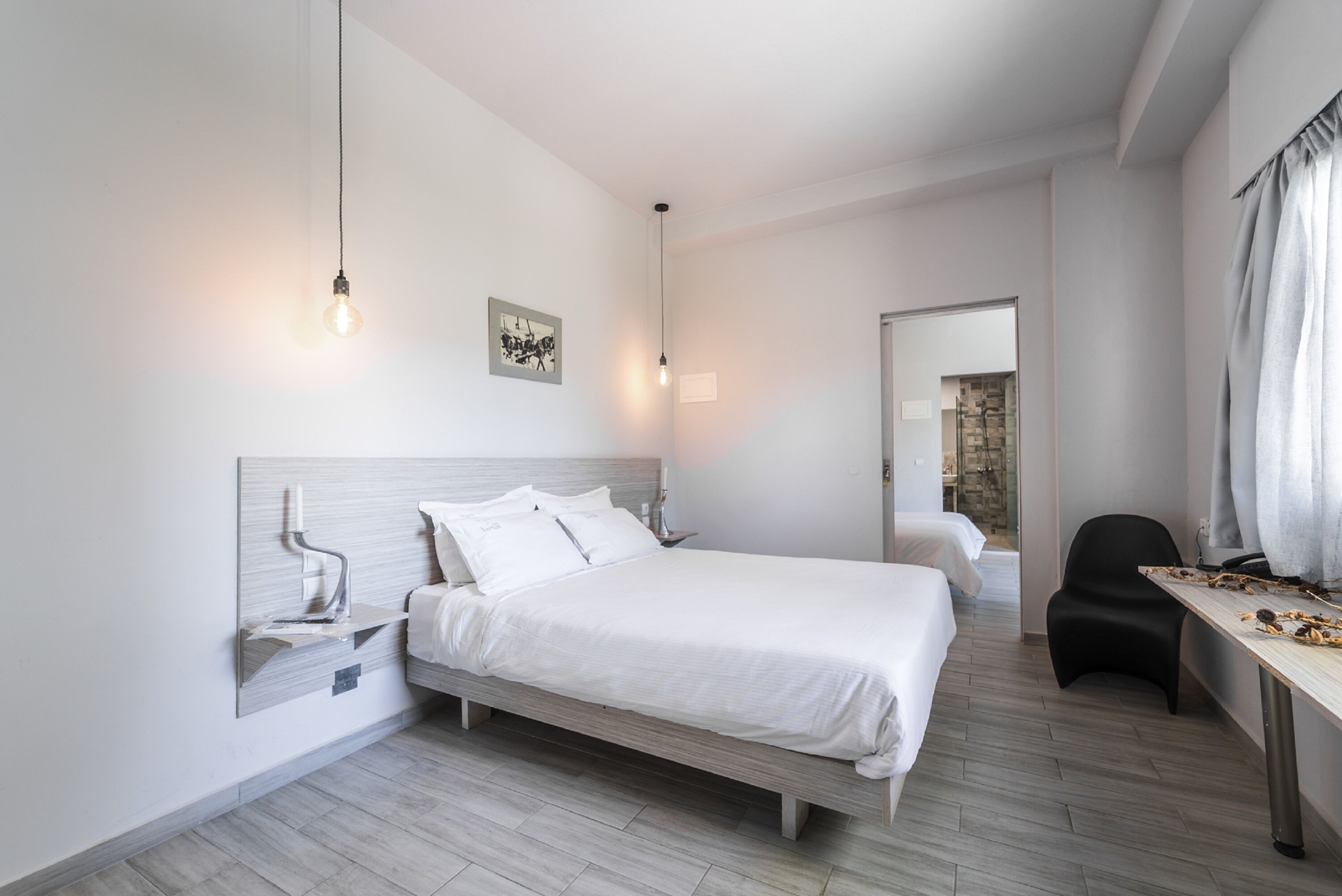 A modern bedroom with a bed, bedside table, and a chair.