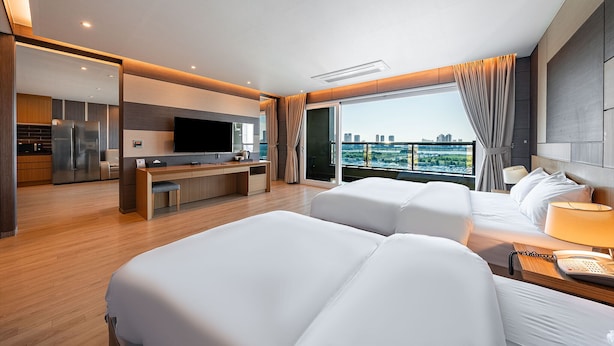 A modern hotel room with a large bed, a desk, a television, and a city view. - Incheon STAY Hotel (Incheon)
