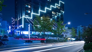 A building with the sign "INCEON STAY" at night, featuring illuminated architectural lines and a clear road with light trails. - Incheon STAY Hotel (Incheon)