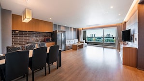 A modern kitchen with a dining area, large windows, and a city view. - Incheon STAY Hotel (Incheon)