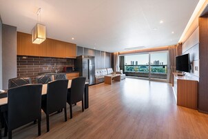 A modern kitchen with a dining area, large windows, and a city view.