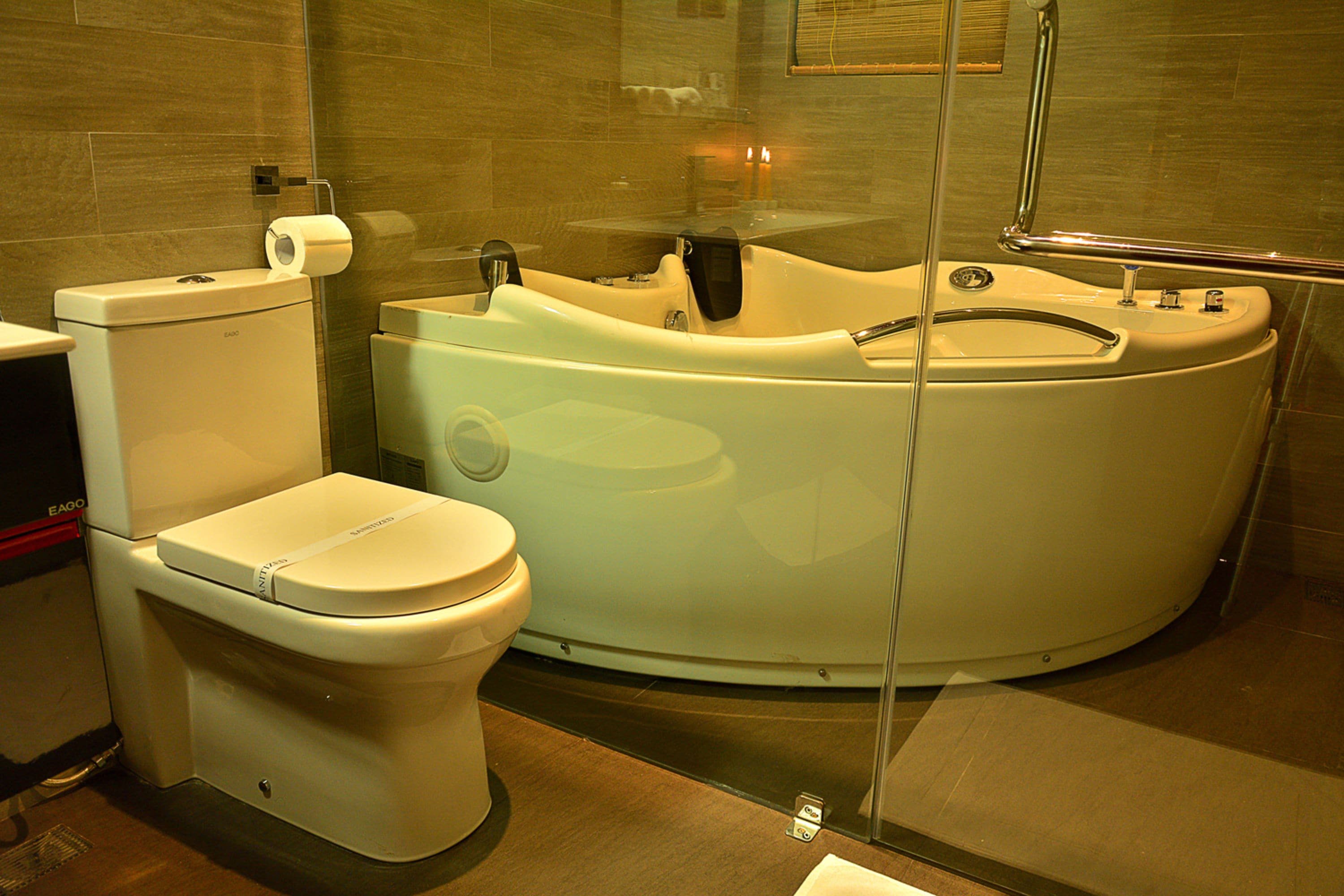 Een moderne badkamer met toilet en een ruime badkuip.