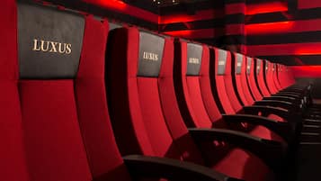 Rows of red and black seats with 'LUXUS' branding, indicating a high-end seating area.