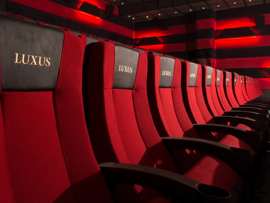 Rows of red and black seats with 'LUXUS' branding, indicating a high-end seating area.