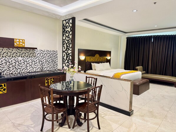 Une chambre d’hôtel dotée d’un coin repas séparé, d’un lit avec une tête de lit, d’un canapé et d’une grande fenêtre avec des rideaux.