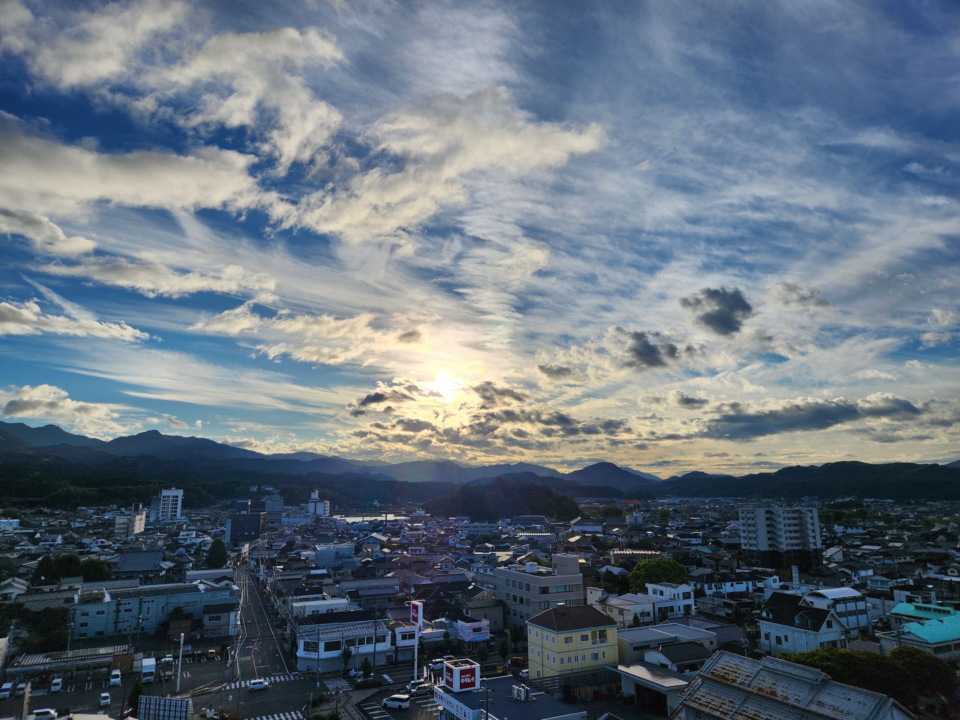 A cityscape with a prominent church, a mix of residential and commercial buildings, and mountains in the background.