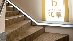 Una escalera con barandilla que conduce a una pared donde se lee el texto 