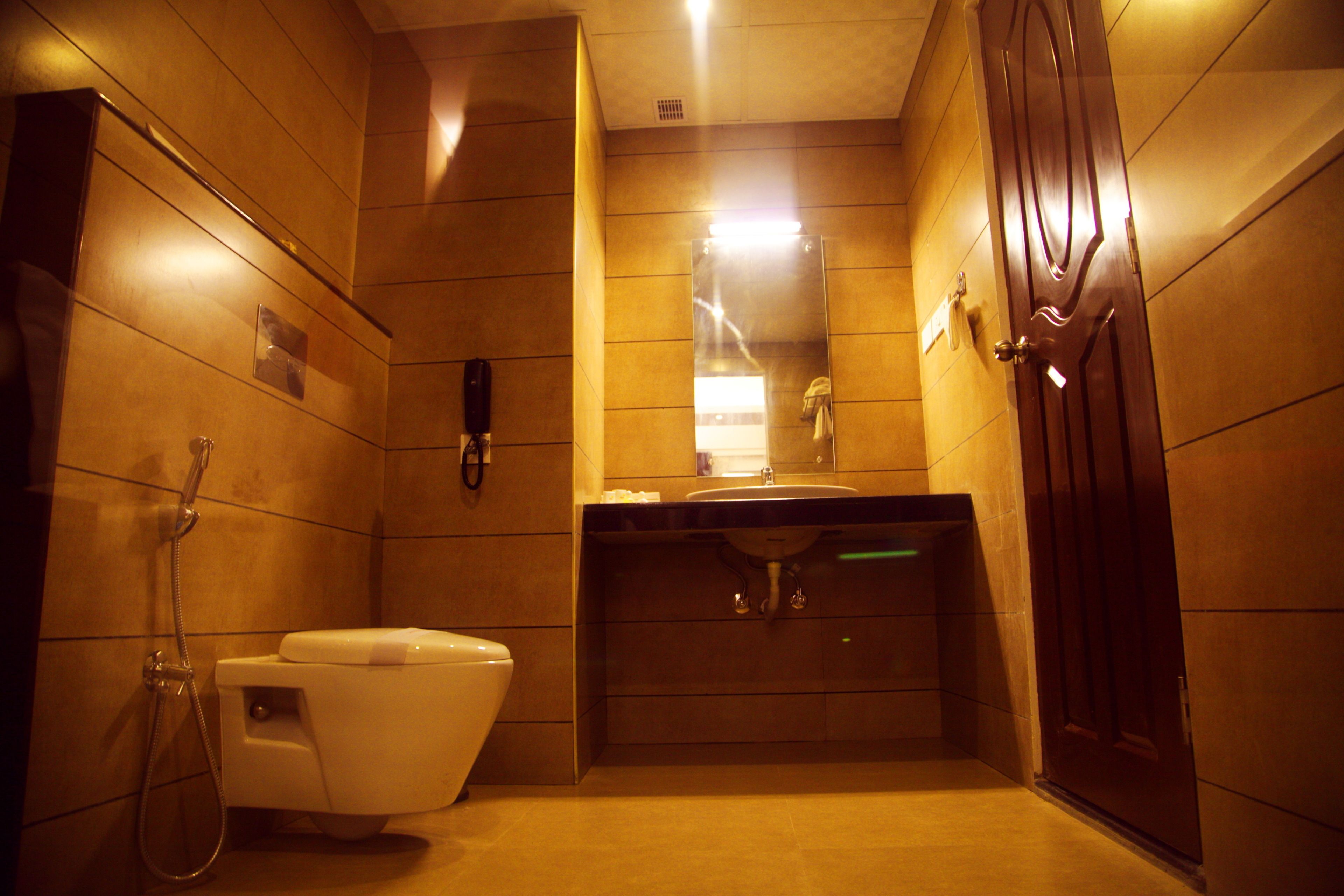 Un baño pequeño con inodoro, lavamanos y ducha.