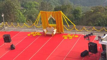 A stage with a red carpet, a white sofa, and yellow floral decorations.