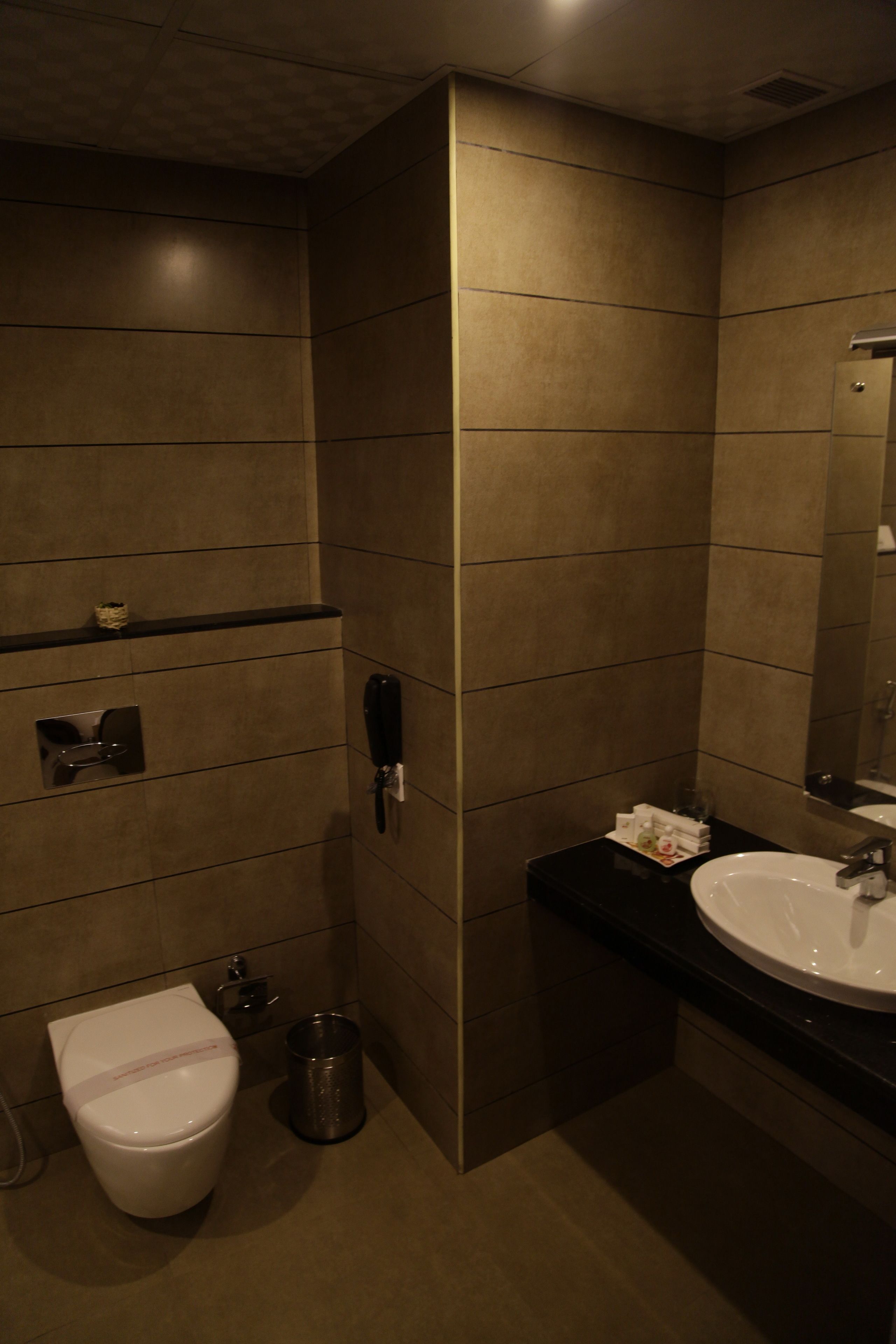 A modern bathroom with a toilet, sink, and mirror.