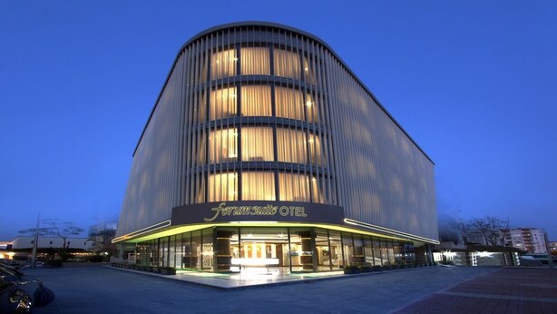 A modern hotel with a curved facade, large windows, and a prominent entrance. - Forum Suite Hotel (Mersin)