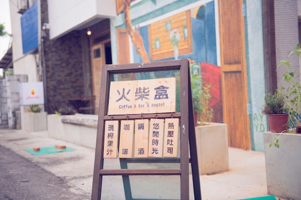 Un letrero con caracteres chinos y texto en inglés para un hostal de café y bar.