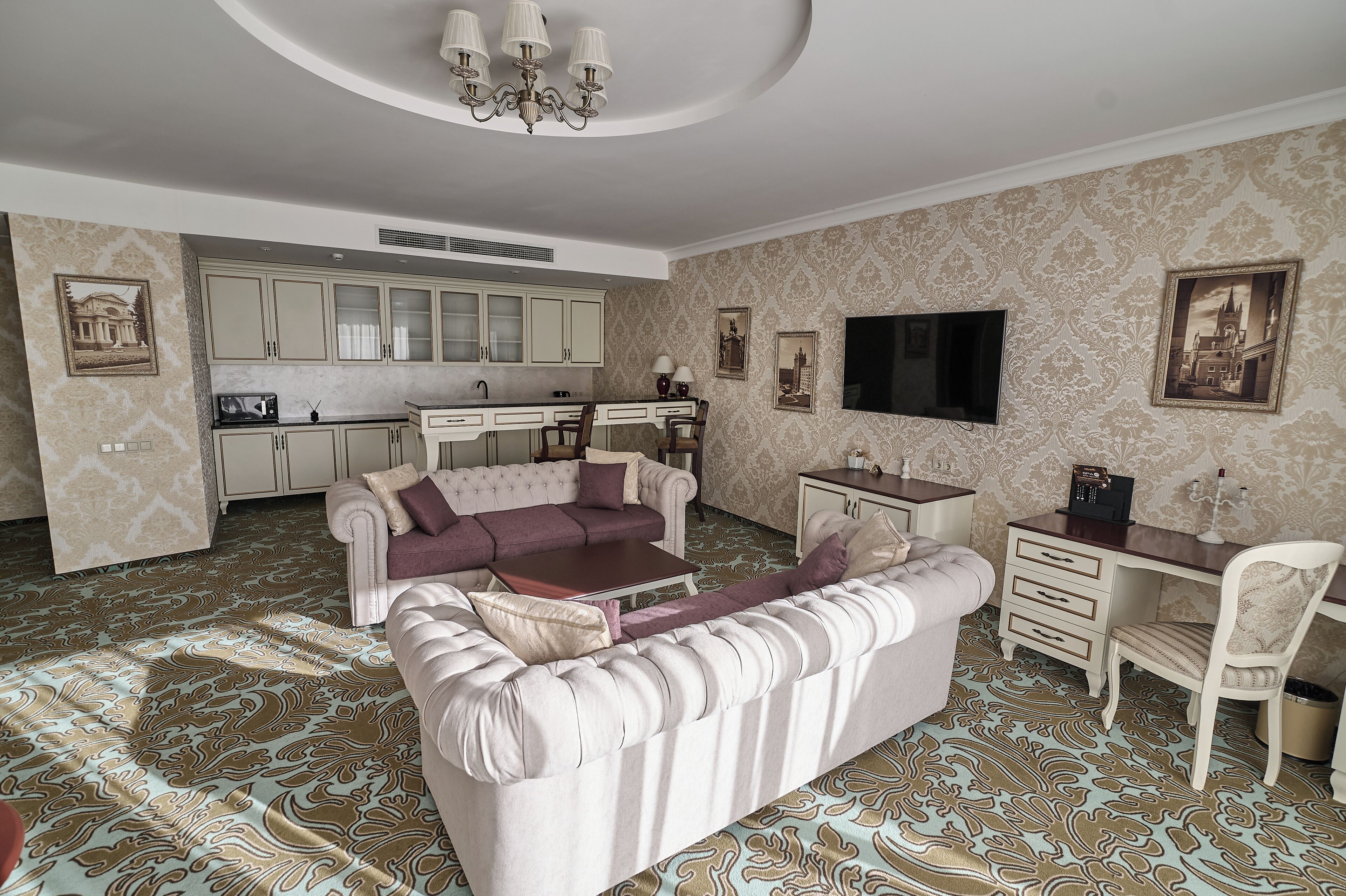 A living room with a sofa, a coffee table, a TV, and a dining area with a table and chairs.