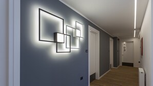 Un corridoio dal design moderno, con opere d'arte geometriche a parete e un tappeto a righe.