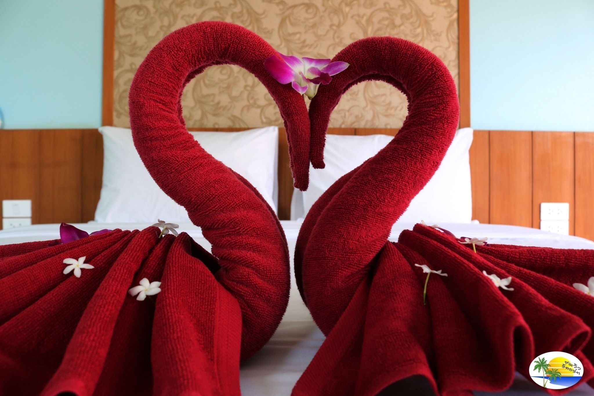 Een hotelkamer met een bed, kussens en een decoratieve wand.