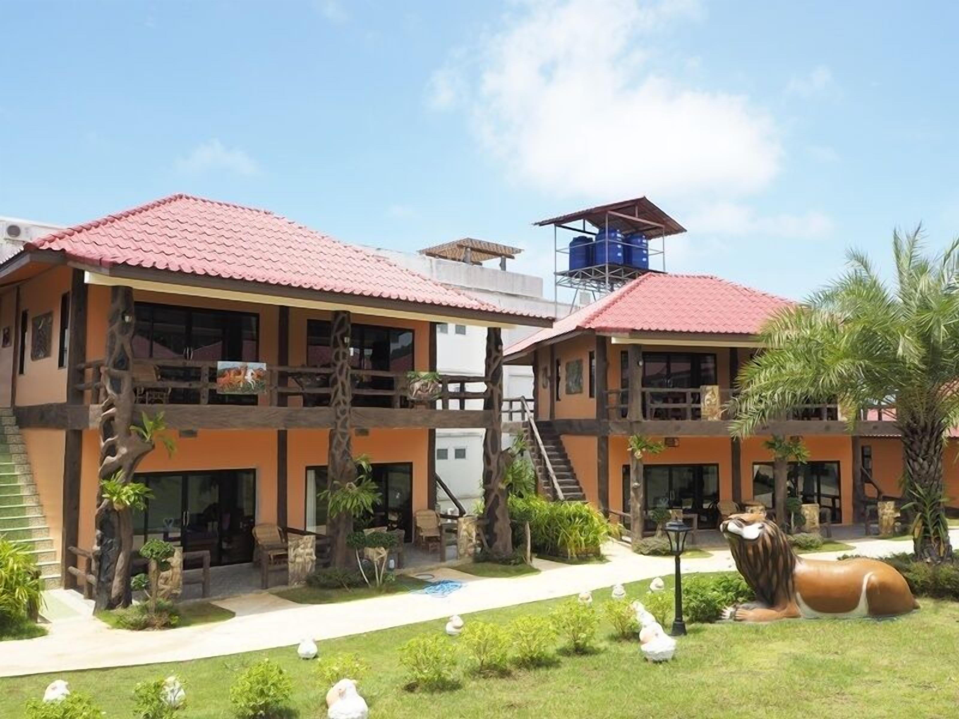 A two-story building with a red-tiled roof, a staircase leading to the upper floor, and a water tank on the roof.