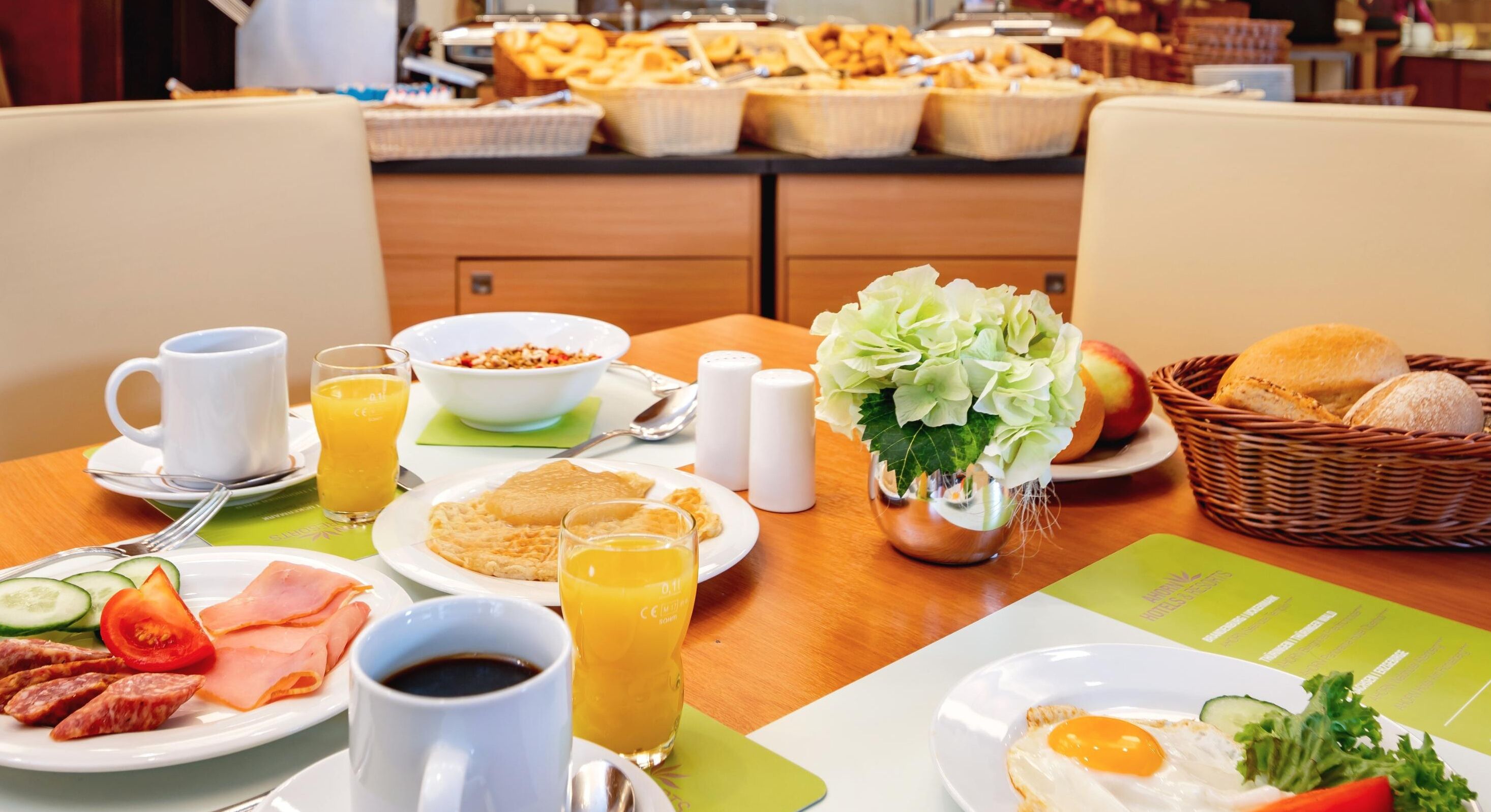 A breakfast buffet with various food items, including eggs, bacon, and pastries.