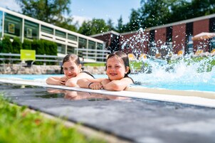 Una piscina cubierta, una piscina al aire libre de temporada, sombrillas