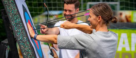 A person aiming an arrow at a target.