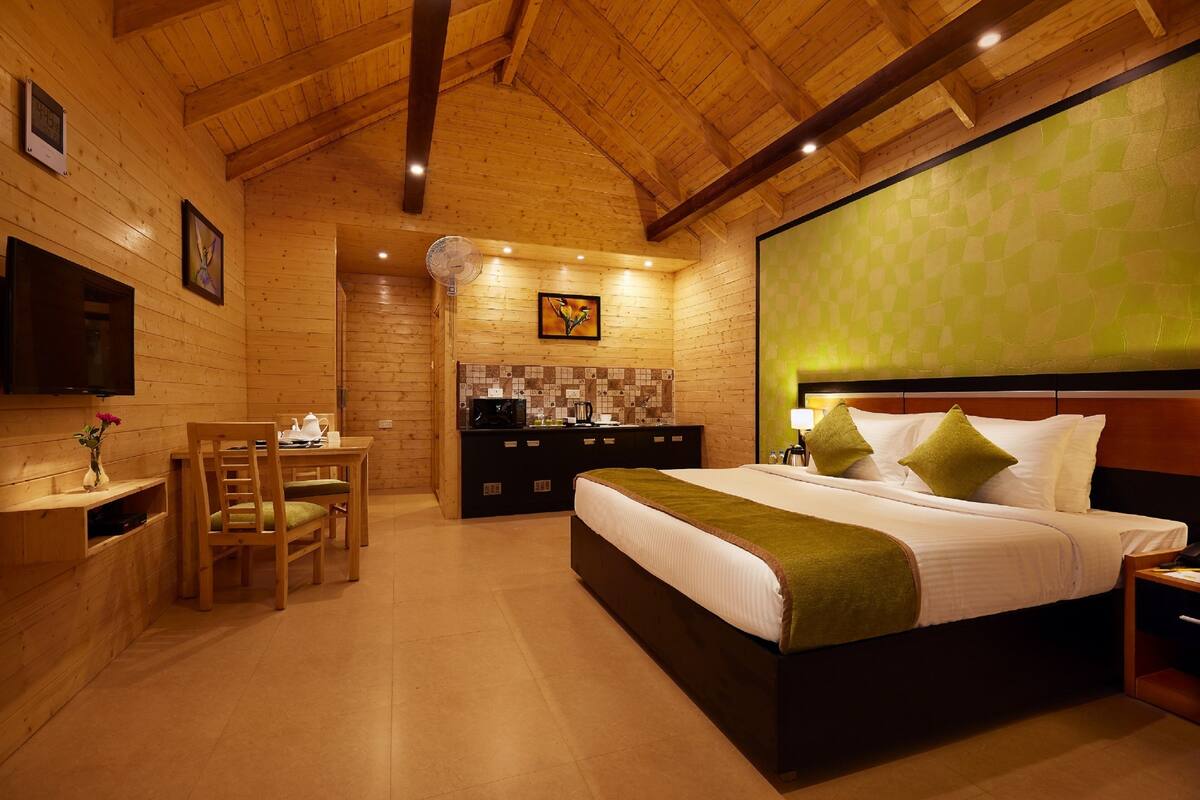 A wooden cabin-style room with a bed, a desk, and a chair.