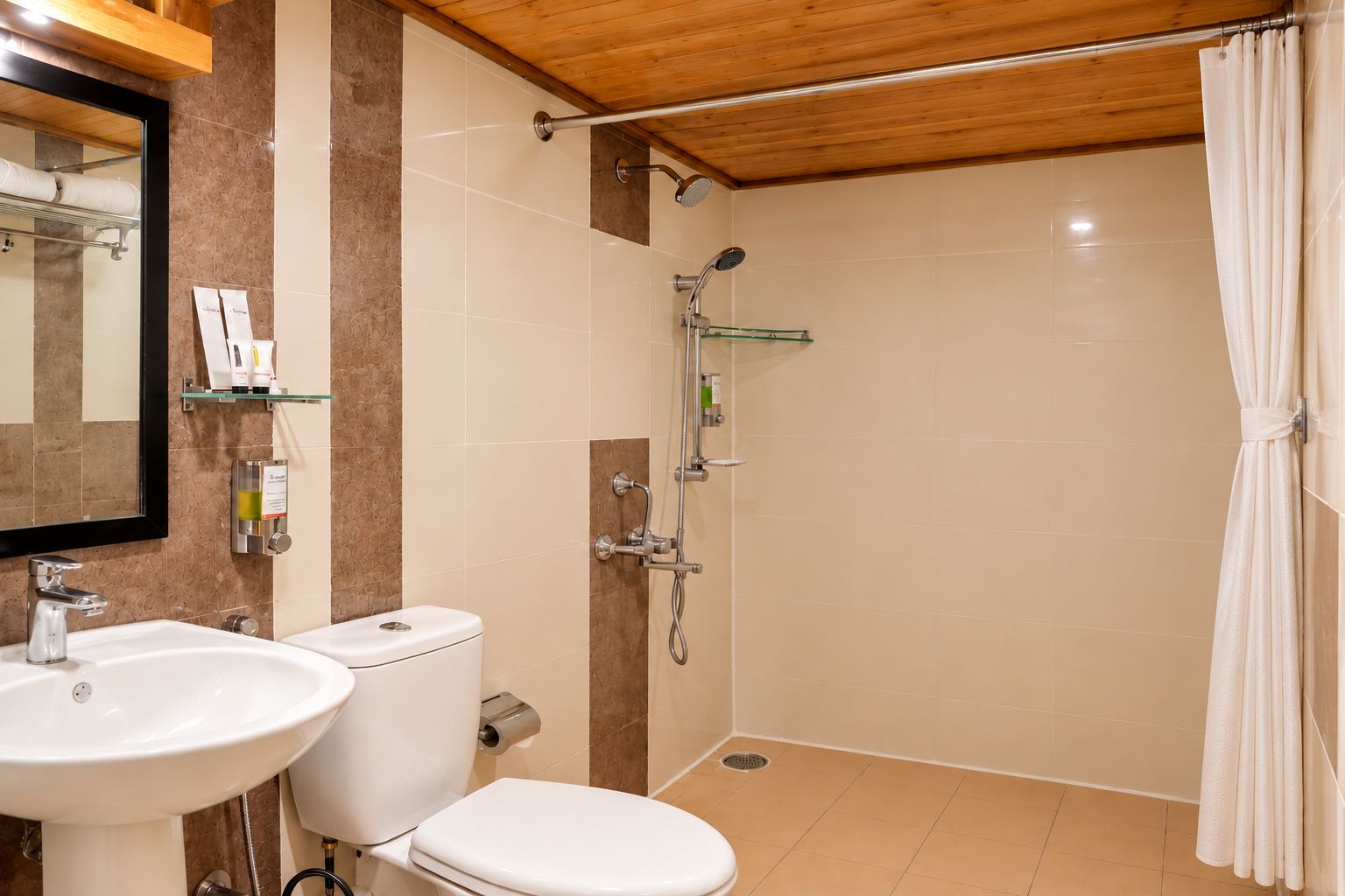 A bathroom with a sink, toilet, shower, and a mirror.