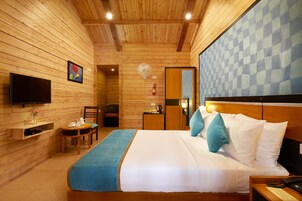 Una habitación con paneles de madera, una cama, un televisor, un escritorio y una silla.