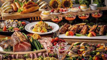 Variedad de alimentos, incluyendo carnes, verduras y frutas, dispuestas sobre una mesa de madera.