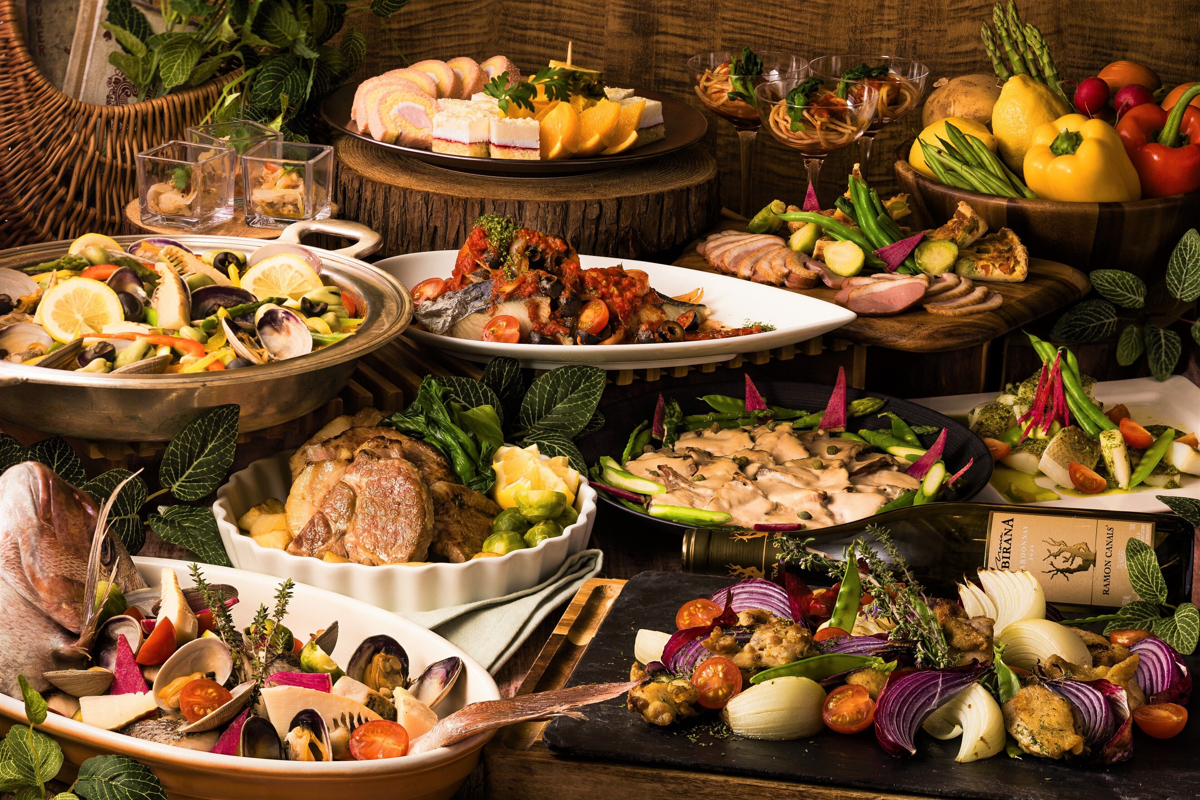 A variety of dishes and a bottle of wine on a wooden table.