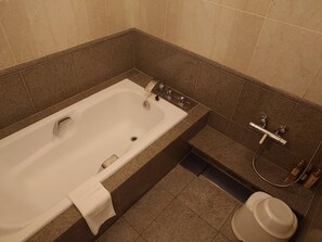 Un baño con bañera, ducha y retrete.