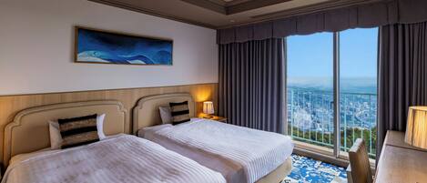 A hotel room with two beds, a city view, a painting on the wall, and a patterned rug.