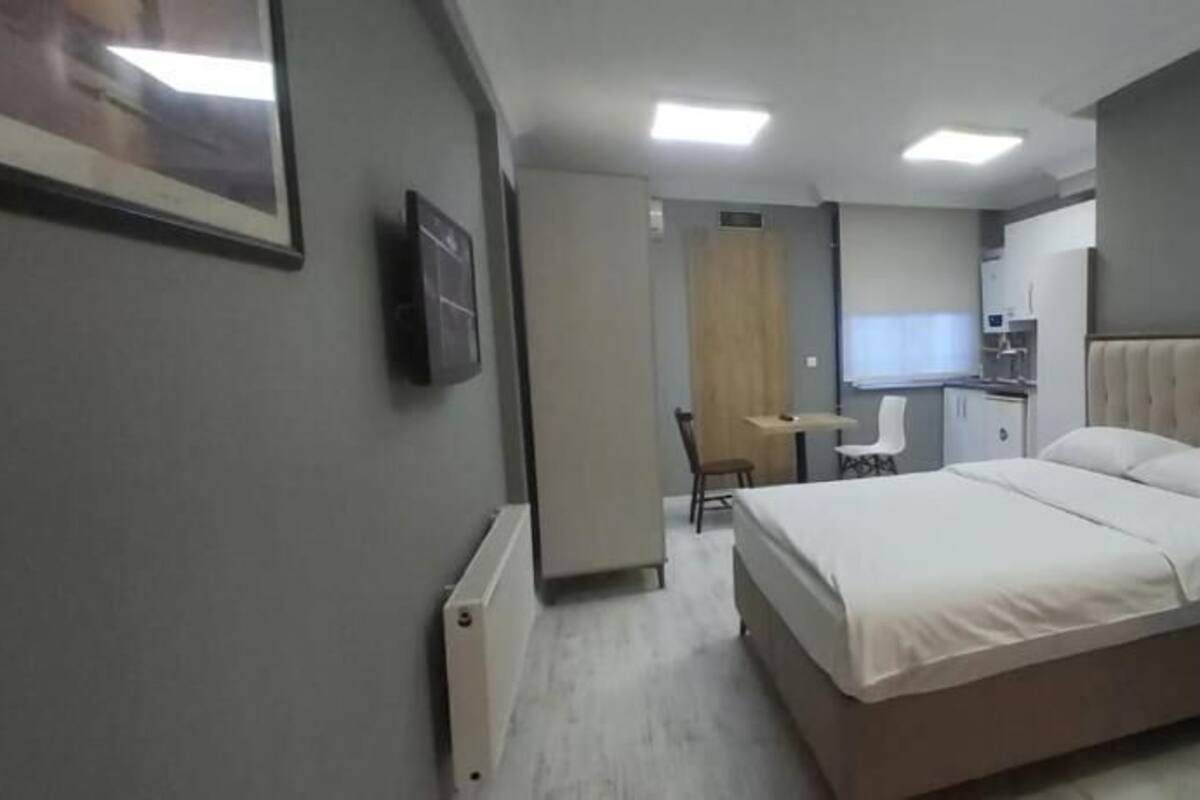 A bedroom with a bed, a desk, and a chair.