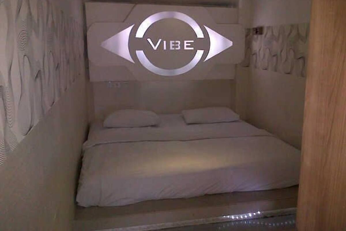 A bedroom with a bed, a headboard with a circular design, and a wall with a textured pattern.