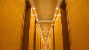A long, narrow hallway with a polished floor and wooden walls.