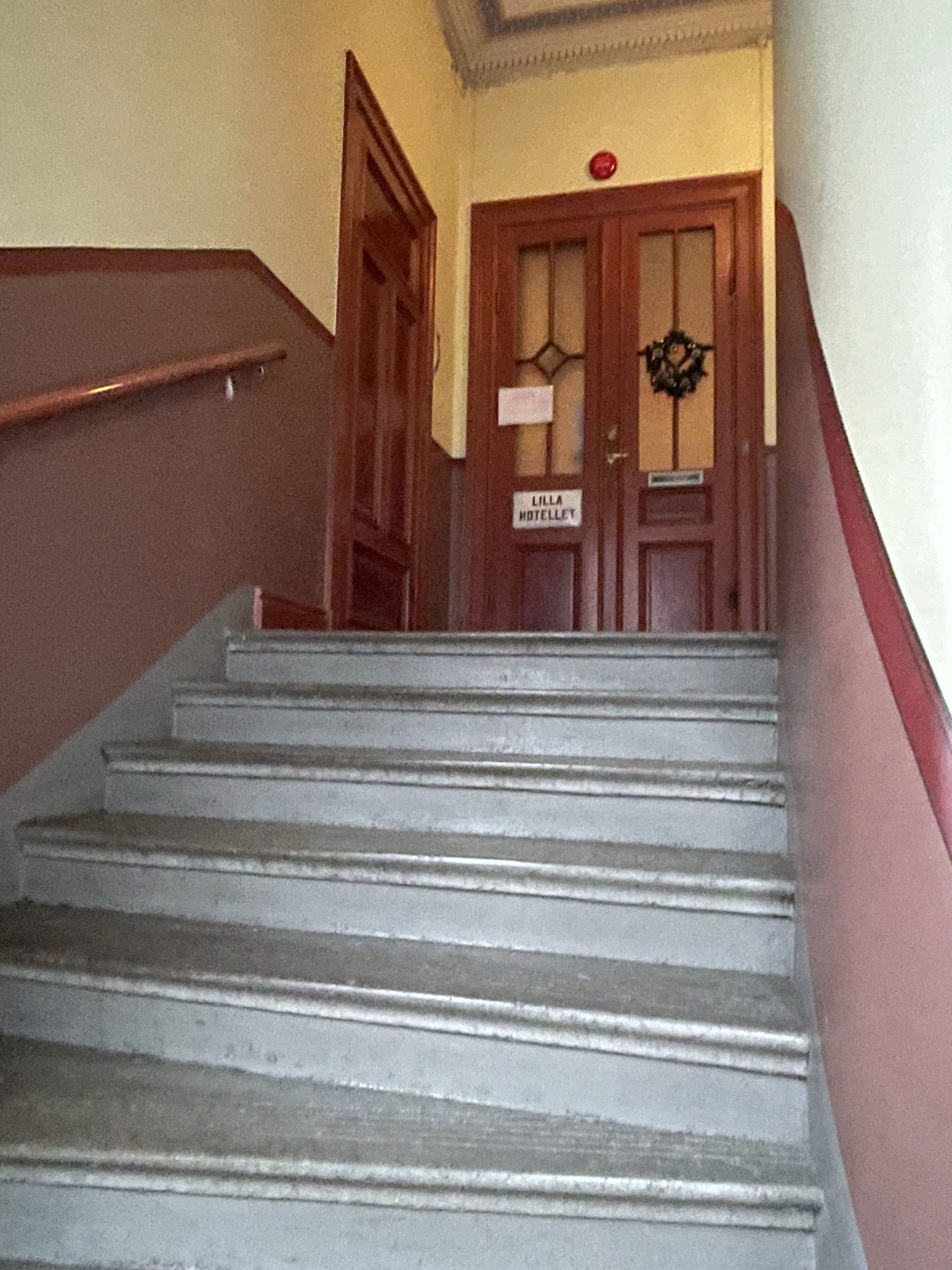A staircase leading to a door labeled "Lilla Hotellet."