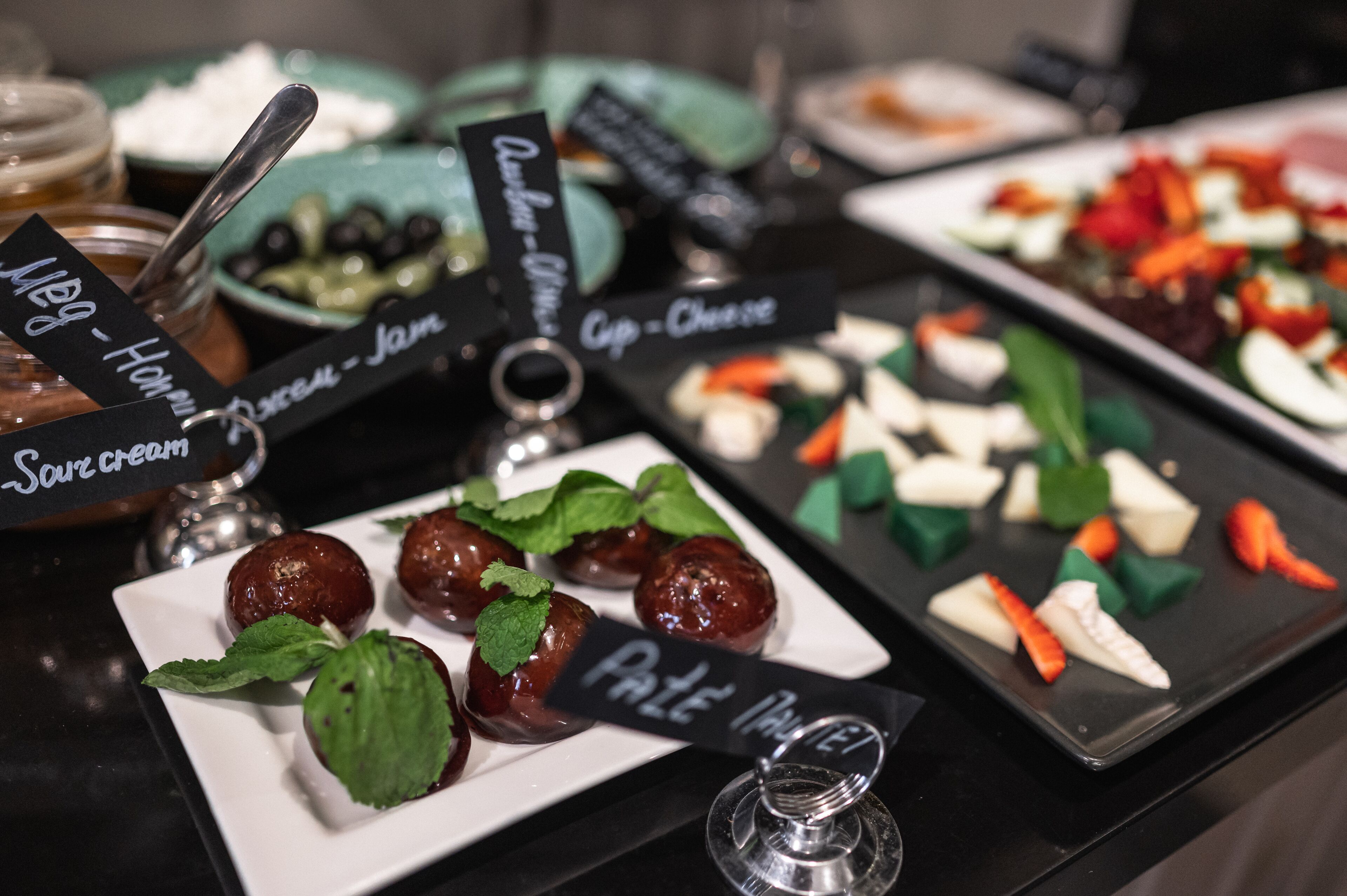 Ein Buffet mit verschiedenen Speisen, darunter 'Sour Cream' und 'Pate'.