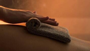 A person receiving a massage with a towel on their back.