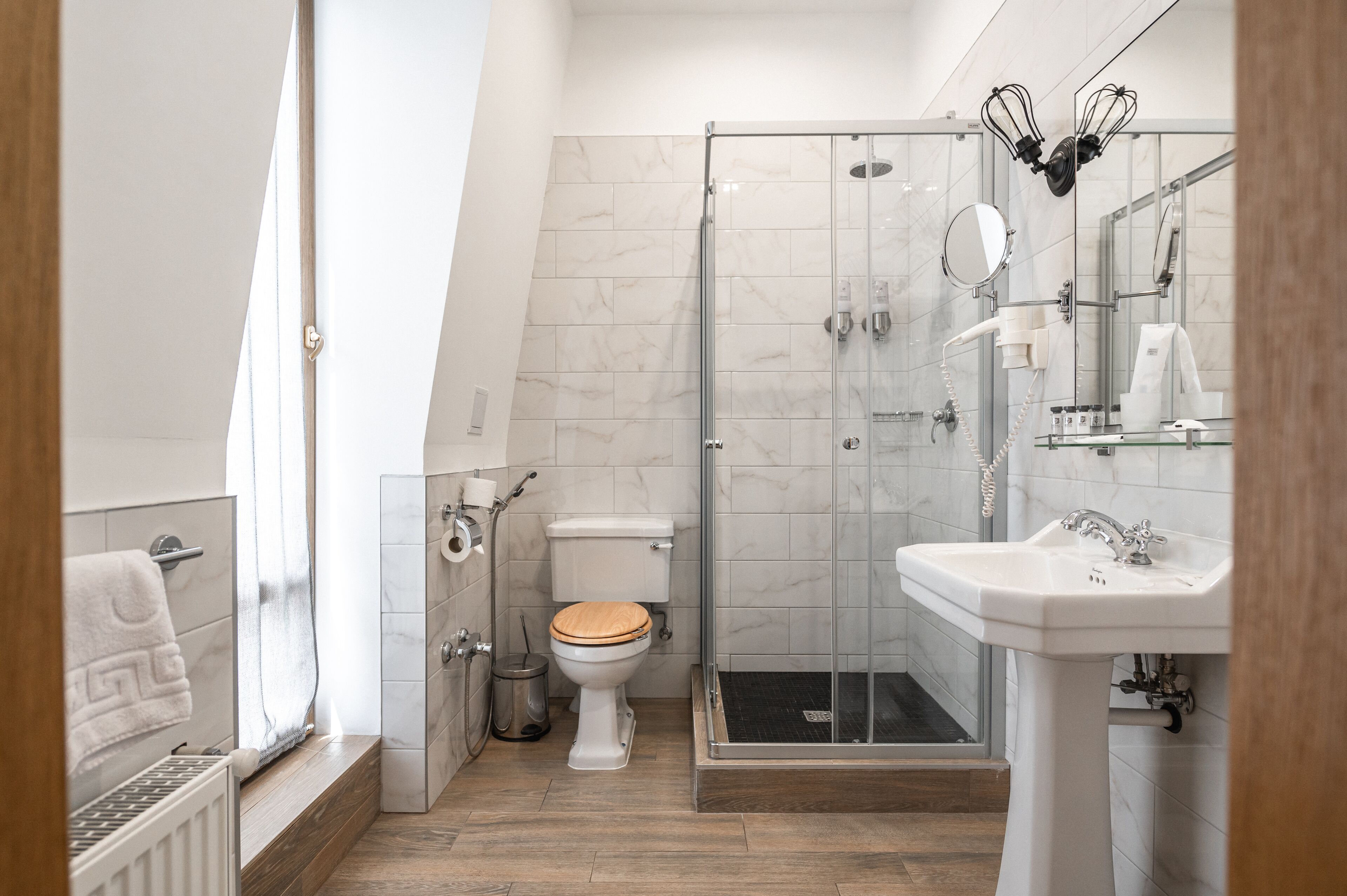 A modern bathroom with a toilet, shower, and sink.