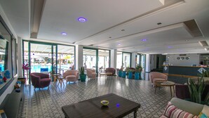 A spacious lobby with a pool view, comfortable seating, and a reception area. - Bahar Hotel (+12 Adult ) (Fethiye)