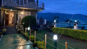A two-story house with a balcony, a well-lit entrance, and a view of mountains in the background. - Royal Mount Hotel (Nuwara Eliya)