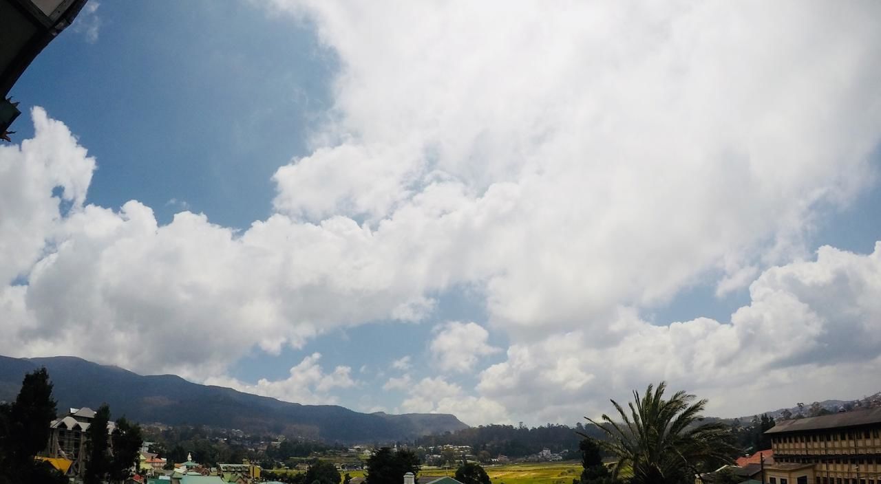 Paisaje con montañas, cielo despejado y edificios en primer plano.