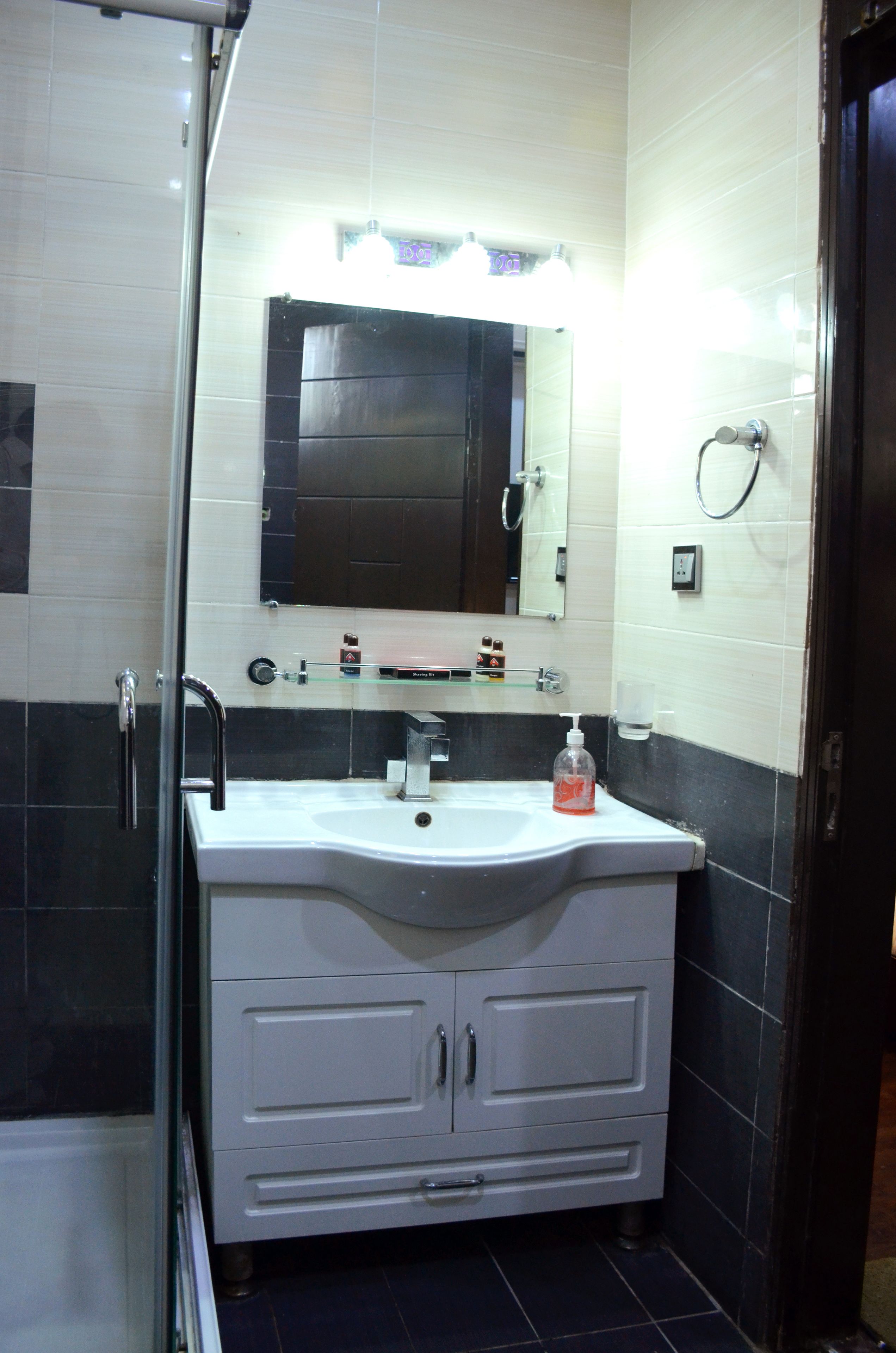 A bathroom with a white sink, a mirror, and a glass shower enclosure.