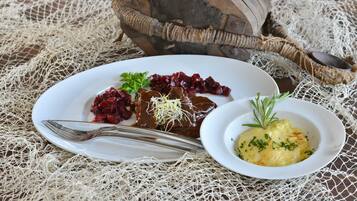 A plate of food with a fork and a wooden bowl.
