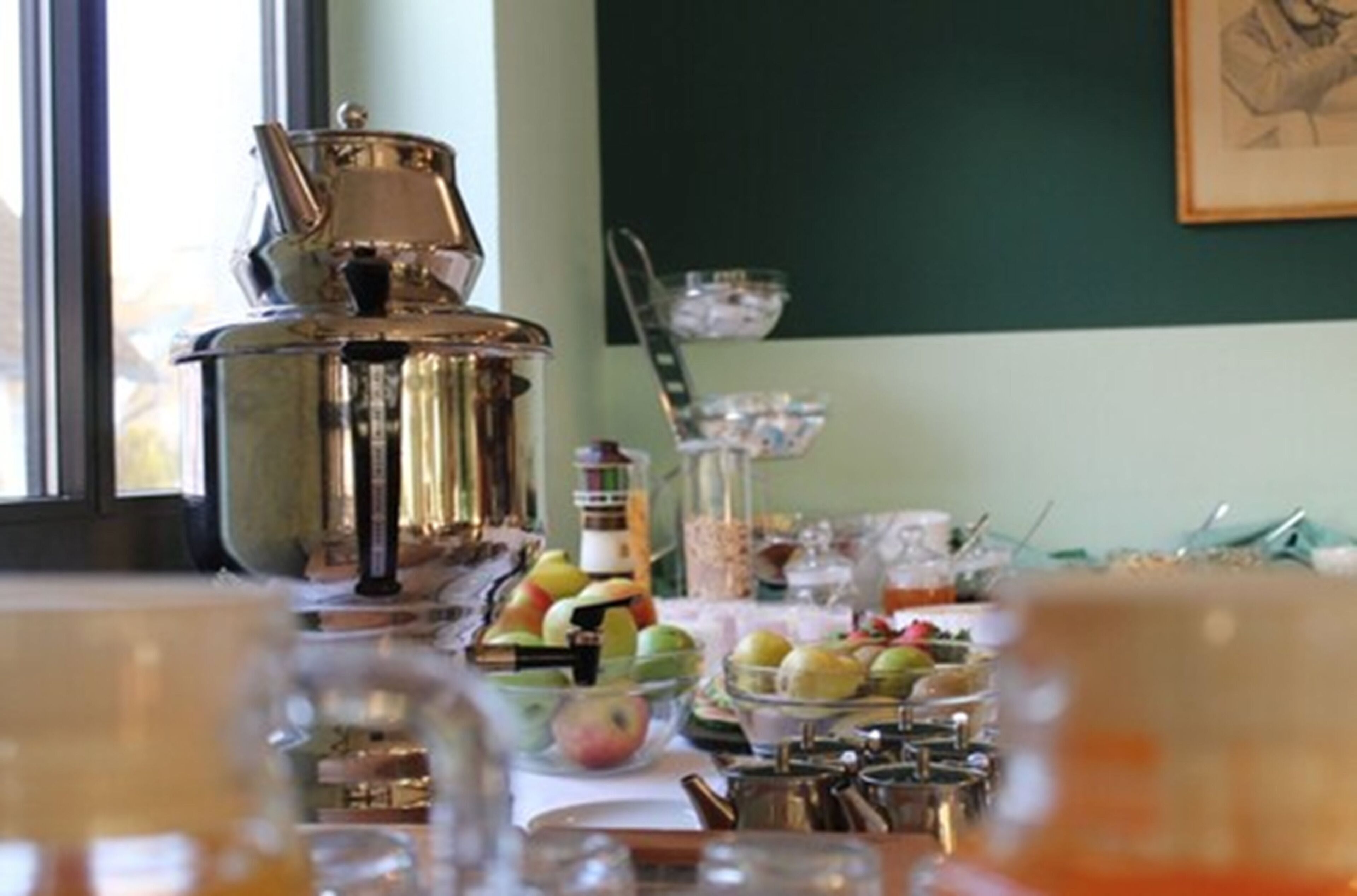 Ein Esstisch mit Kaffeekanne, Obstschale und verschiedenen Frühstücksangeboten.