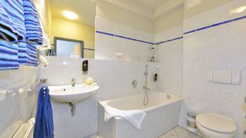 A bathroom with a bathtub, sink, and toilet.