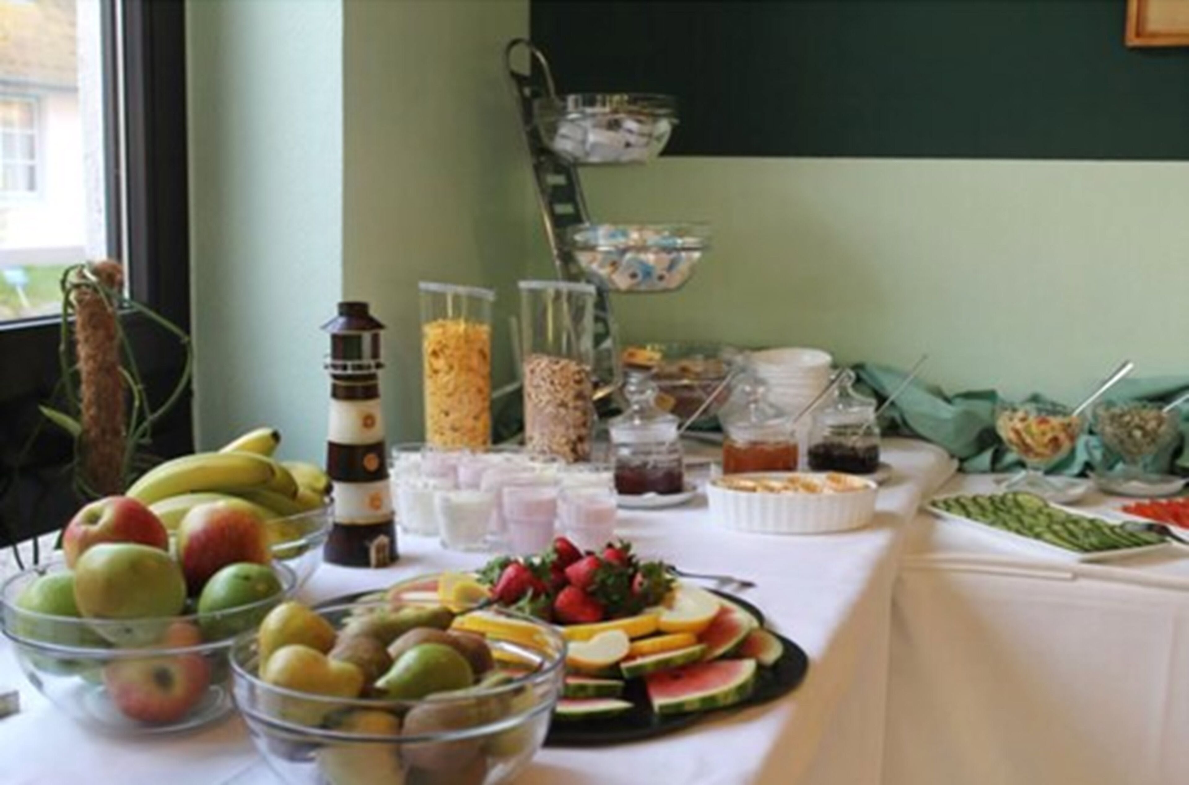 A buffet table with various fruits, beverages, and condiments.