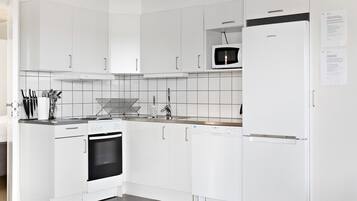 A modern kitchen with white cabinets, a microwave, a Samsung refrigerator, and a dishwasher.