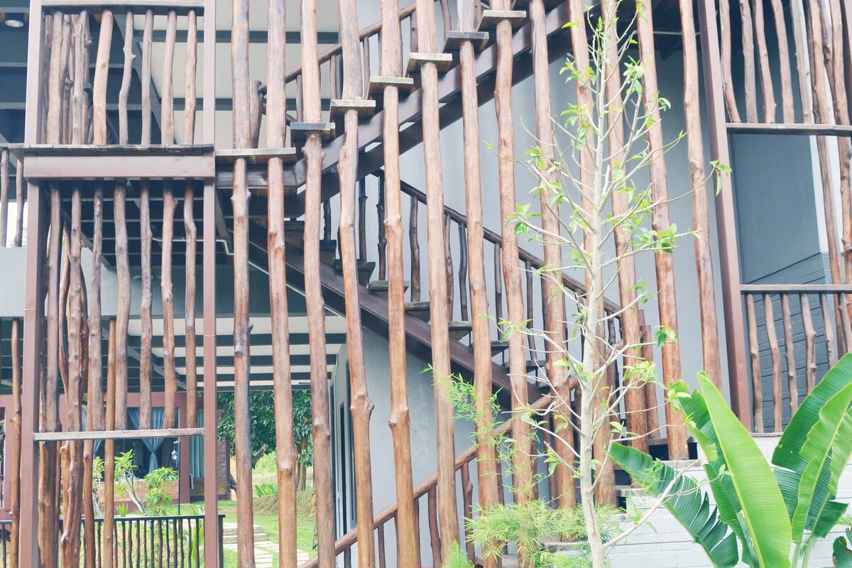 Un edificio de varios pisos con una fachada de madera original y una escalera central.