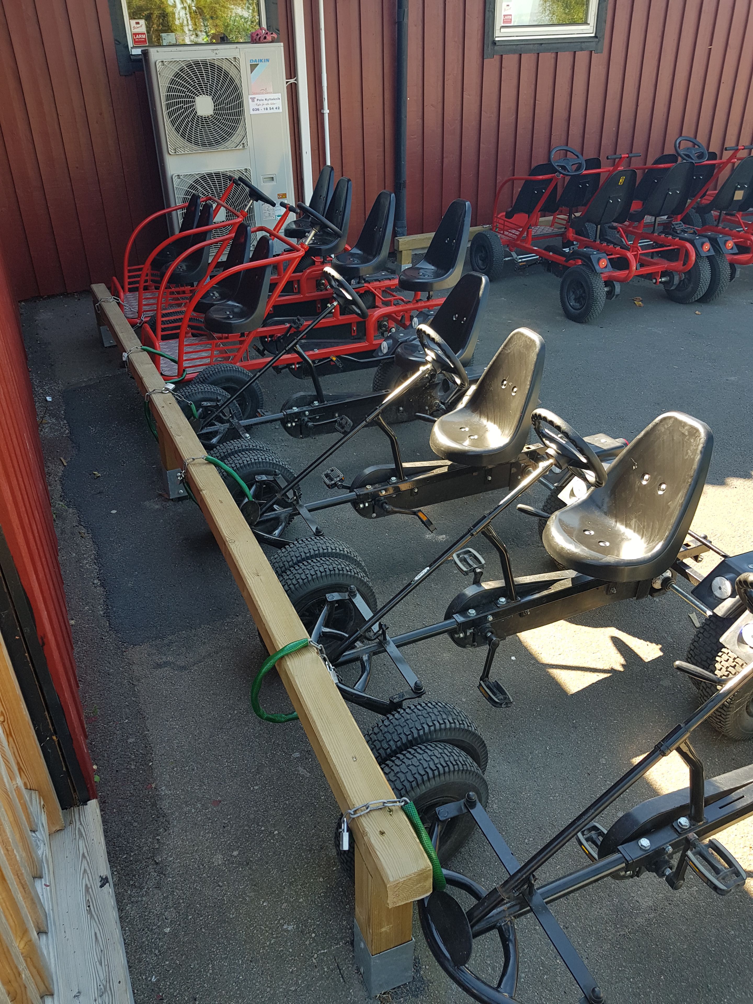 Una hilera de karts alineados frente a un edificio con fachada de madera.