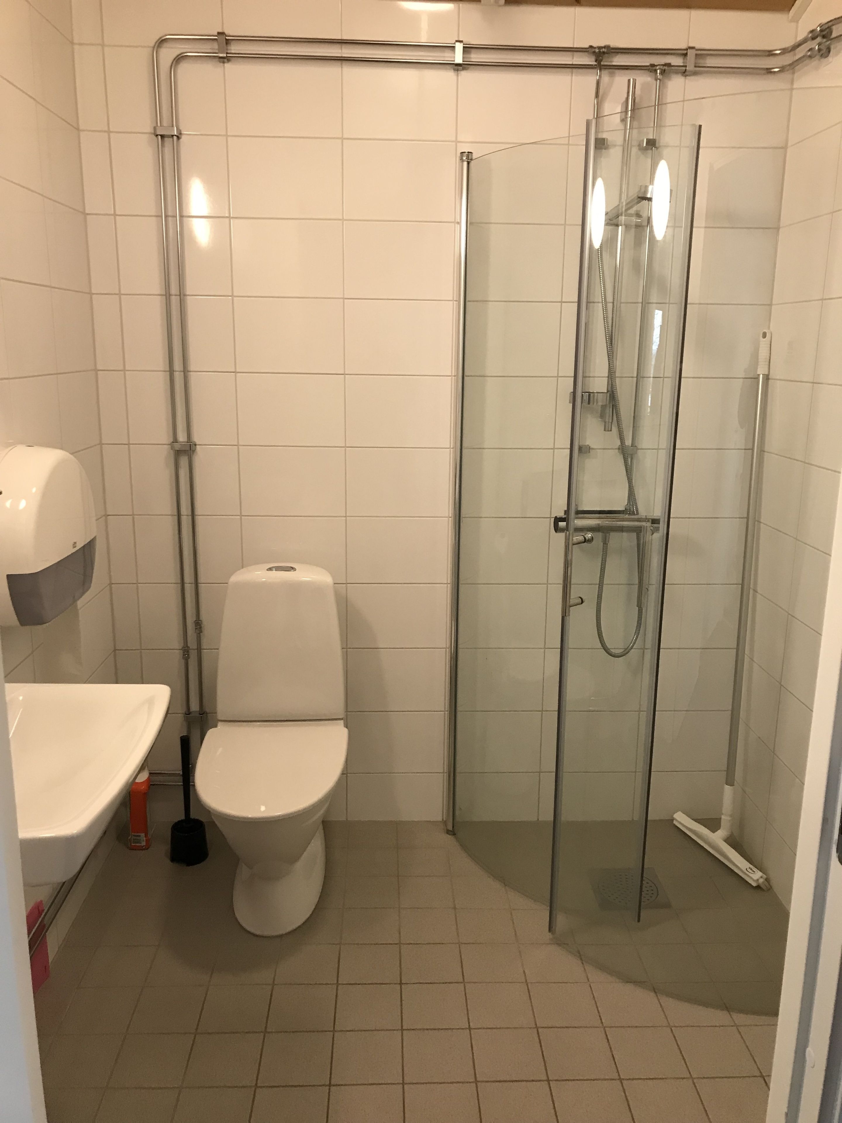 A bathroom with a toilet, a sink, and a glass-enclosed shower area.