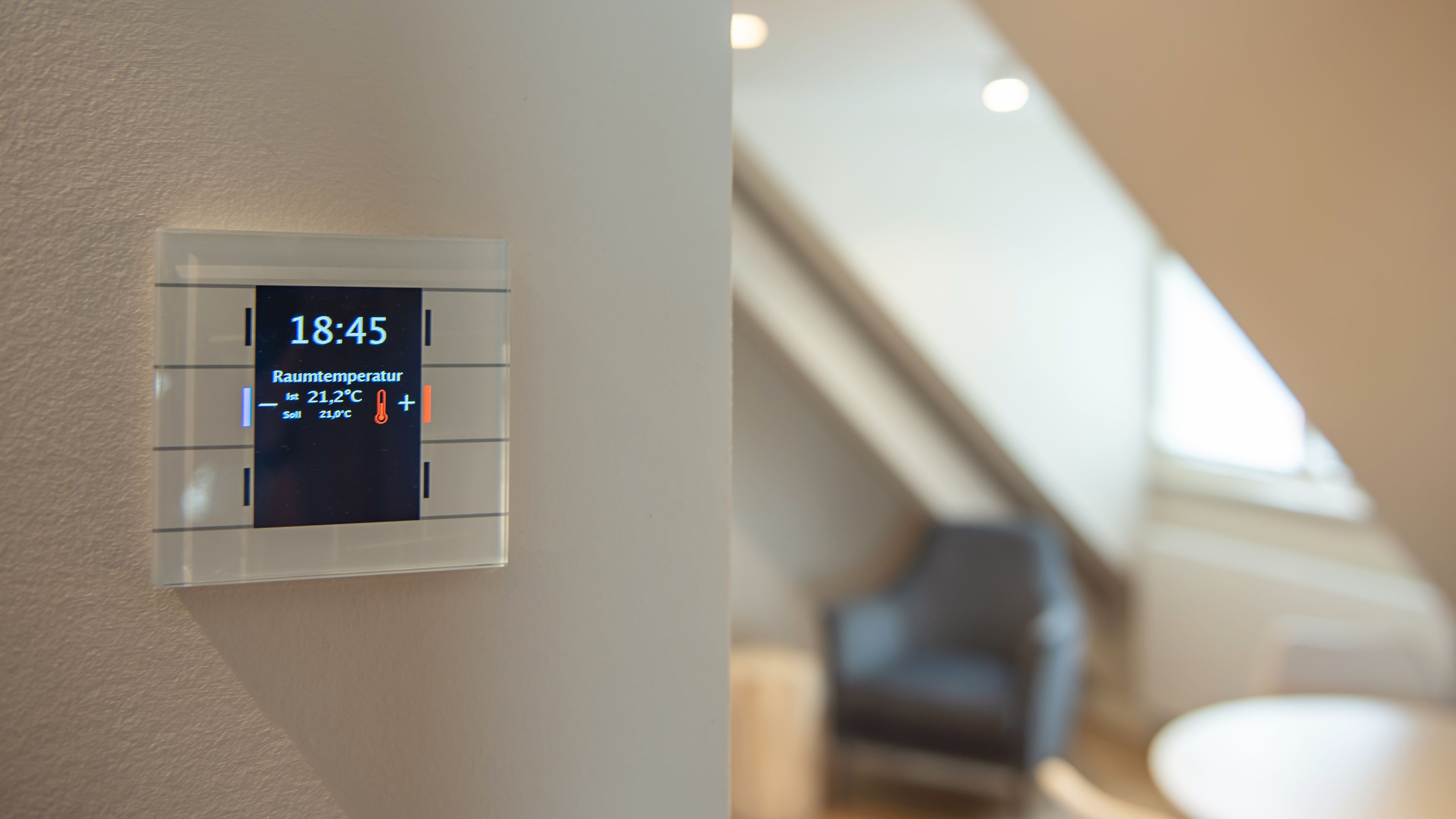 A digital thermostat displaying the time as 18:45 and room temperature as 21.2°C.